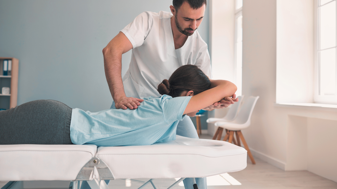 Physiotherapist treating patient with back pain using manual therapy