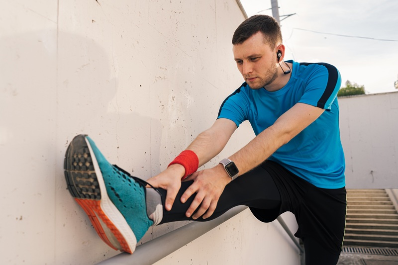 man stretcging in running gear