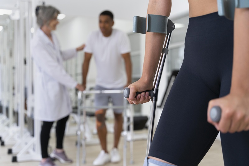 woman on crutches man with walker and strapped knee