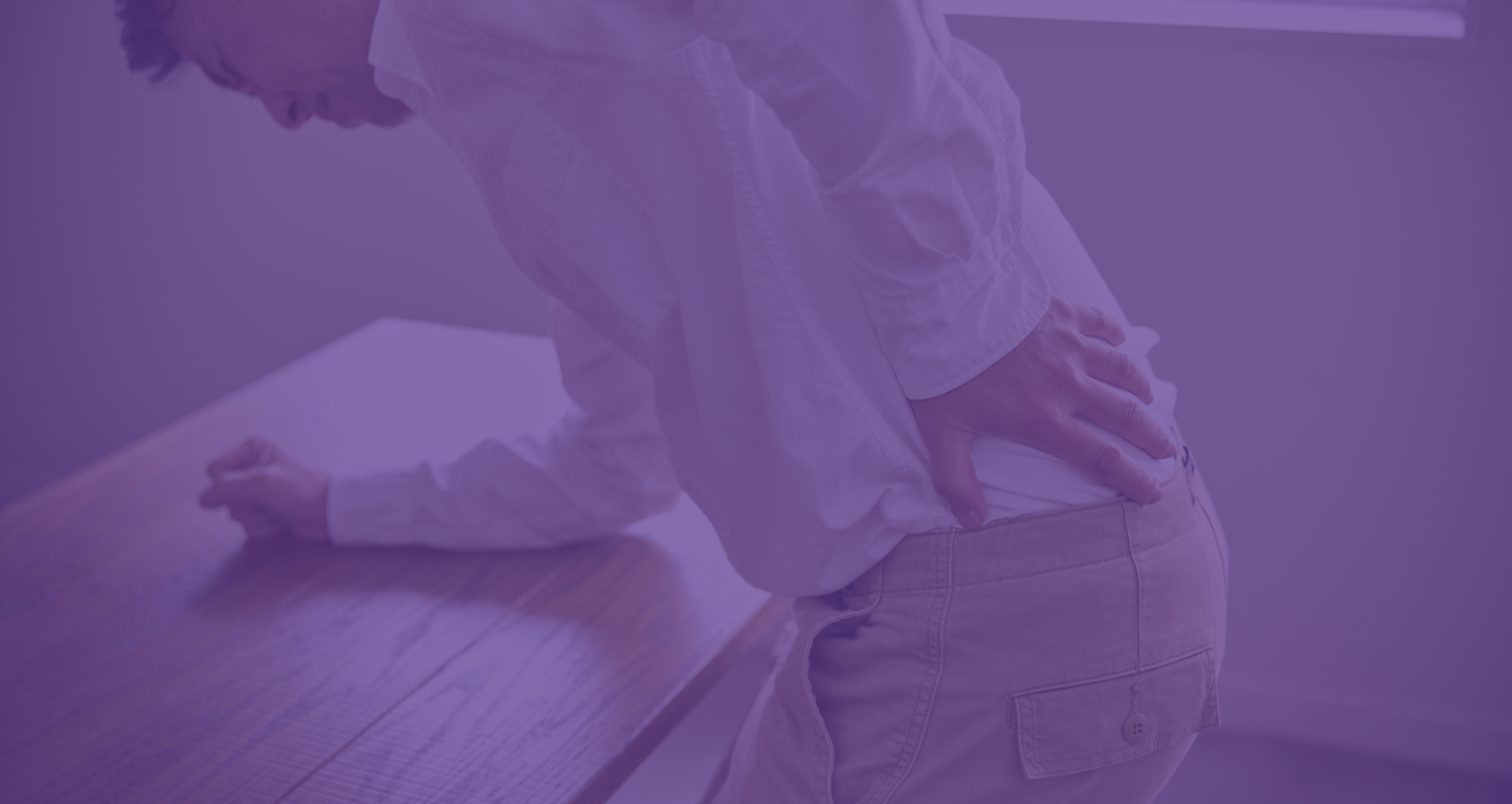 man bent over holding lower back in pain